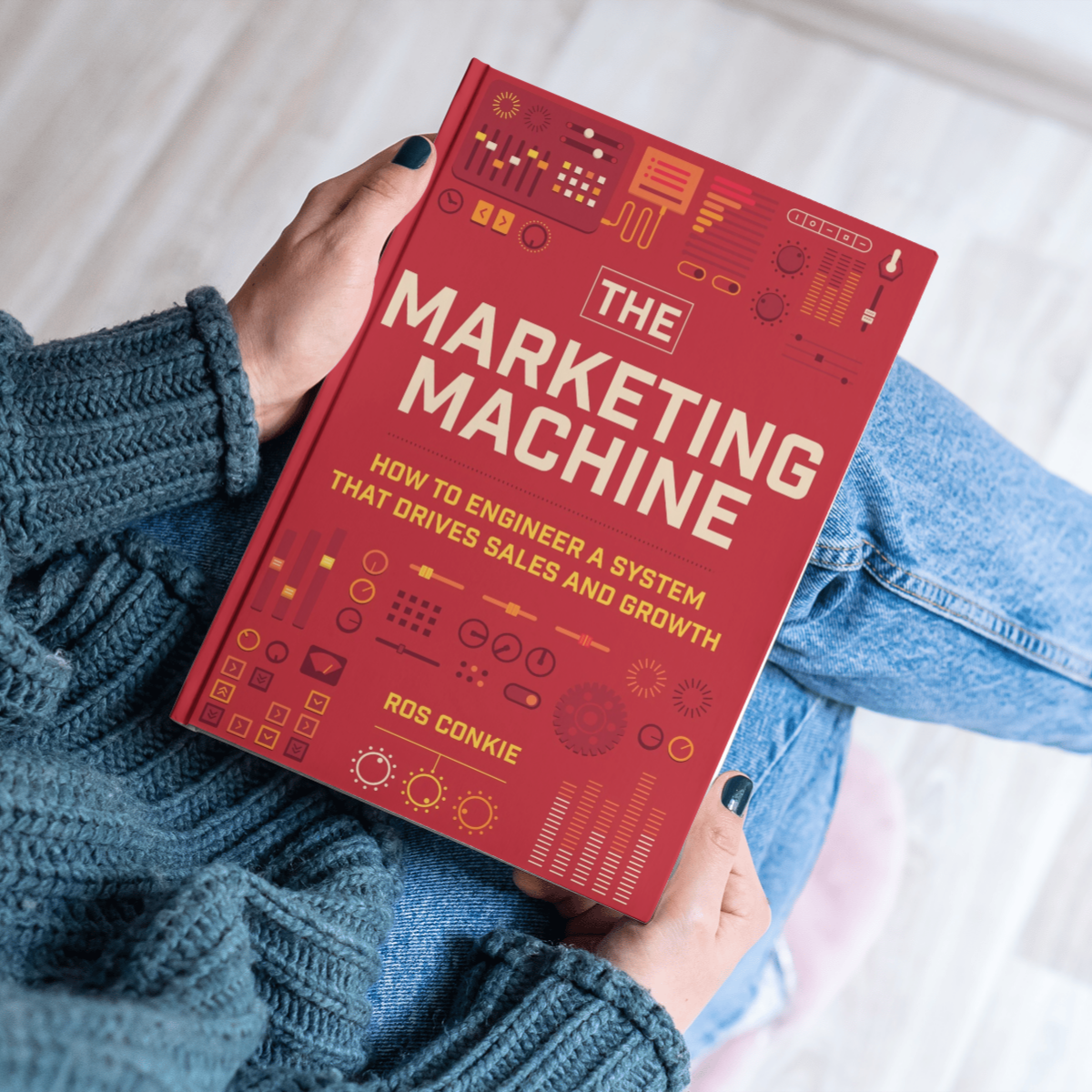Person holding The Marketing Machine book on their lap