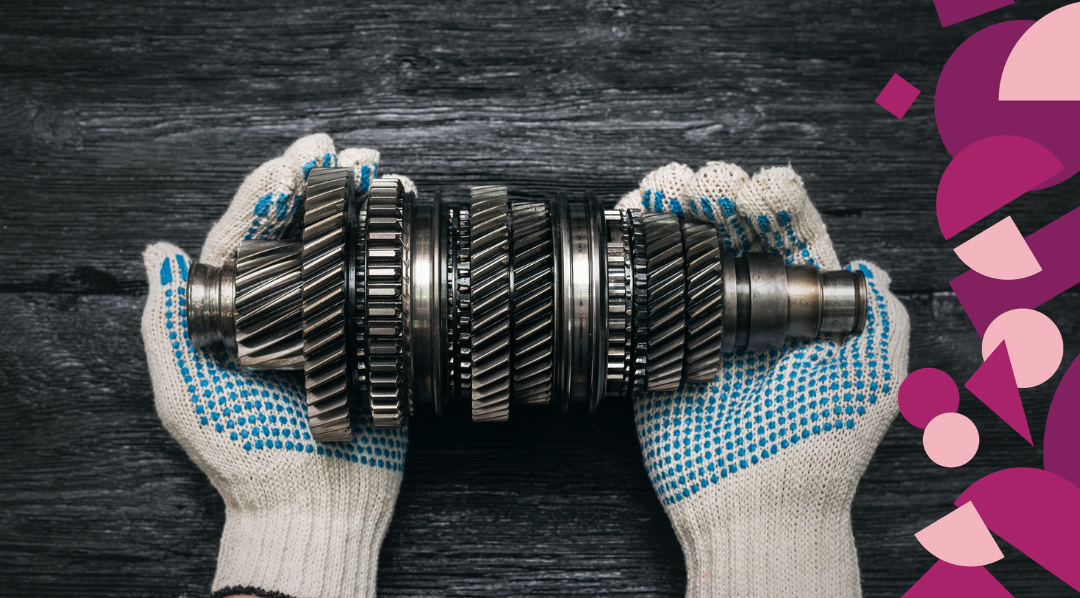 Hands holding a metal gearbox, illustrating the importance of choosing the right marketing strategy before selecting channels and tactics.